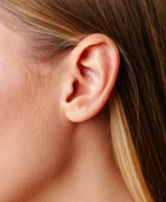 womans-ear-close-up-with-green-background-2025-02-25-12-49-52-utc